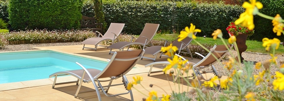 Piscine bordée de chaises longues avec vue sur la montagne